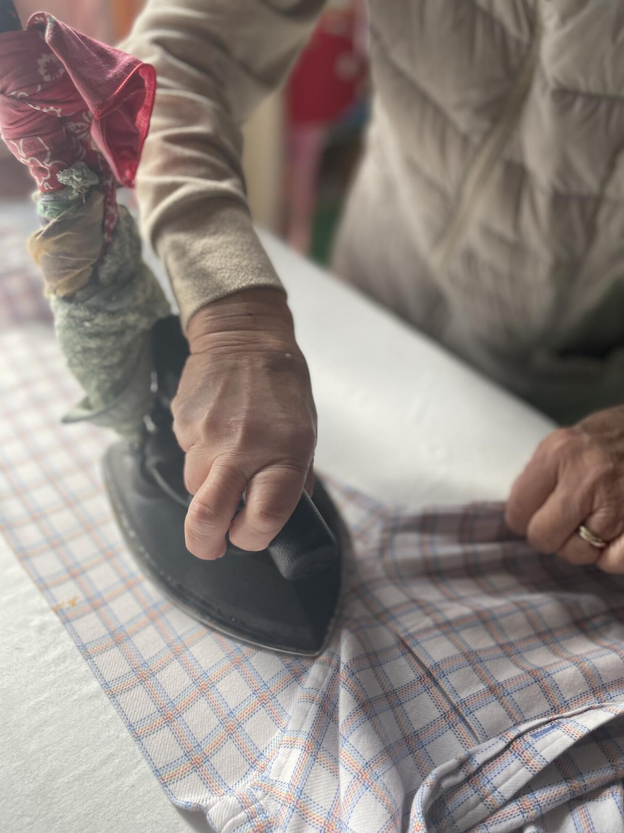 職人がシャツをを丁寧に手アイロンで仕上げている